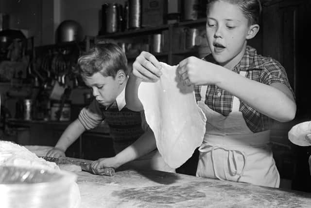 circa 1955: Young television stars Glenn (left) and Ronnie Walken, later film star Christopher Walken, roll out dough for pie crusts at their father's bakery. (Photo by Orlando /Three Lions/Getty Images)