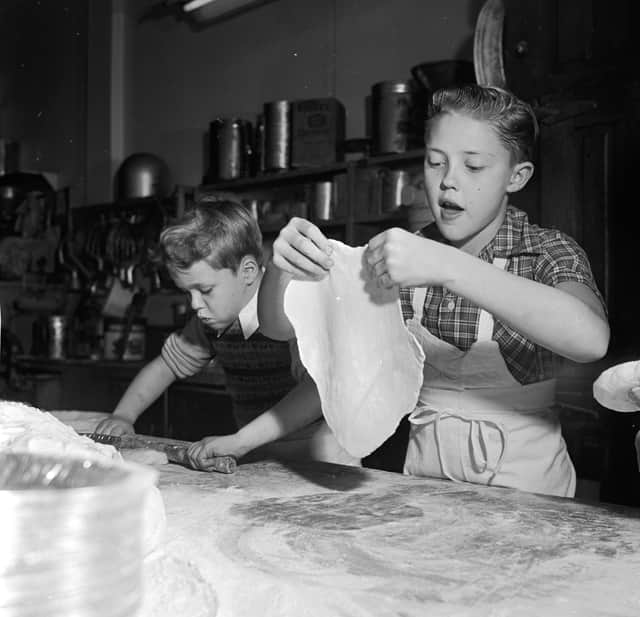 circa 1955:  Young television stars Glenn (left) and Ronnie Walken, later film star Christopher Walken, roll out dough for pie crusts at their father's bakery.  (Photo by Orlando /Three Lions/Getty Images)