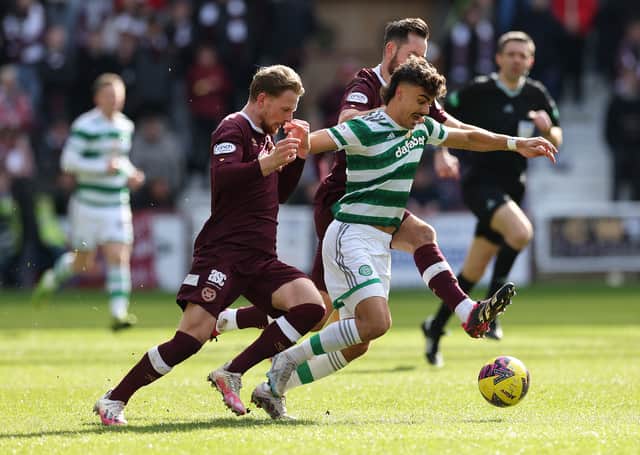 Jota of Celtic evades Orestis Kiomourtzoglou and Jorge Grant of Hearts at Tynecastle