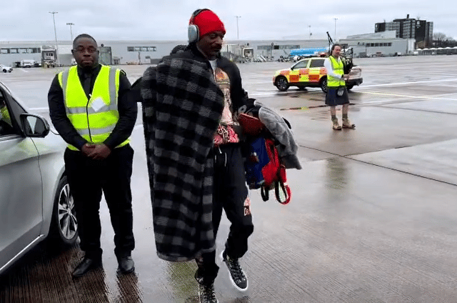 Snoop Dogg steps to the drone of bagpipe player Ross Ainslie at the airport runway prior to his gig at the Hydro tonight, March 16.