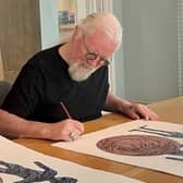 Billy Connolly signs his artwork