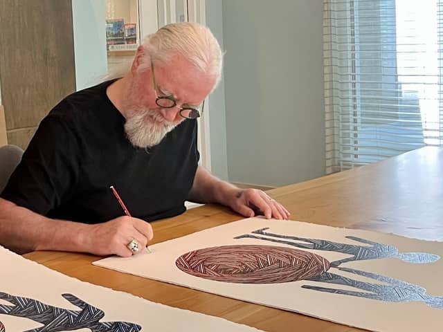 Billy Connolly signs his artwork
