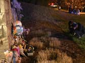 People gather at a makeshift memorial for victims outside the Covenant School building at the Covenant Presbyterian Church following a shooting, in Nashville, Tennessee, on March 27, 2023. - A heavily armed former student killed three young children and three staff in what appeared to be a carefully planned attack at a private elementary school in Nashville on Monday, before being shot dead by police. Chief of Police John Drake named the suspect as Audrey Hale, 28, who the officer later said identified as transgender. (Photo by Brendan SMIALOWSKI / AFP) (Photo by BRENDAN SMIALOWSKI/AFP via Getty Images)