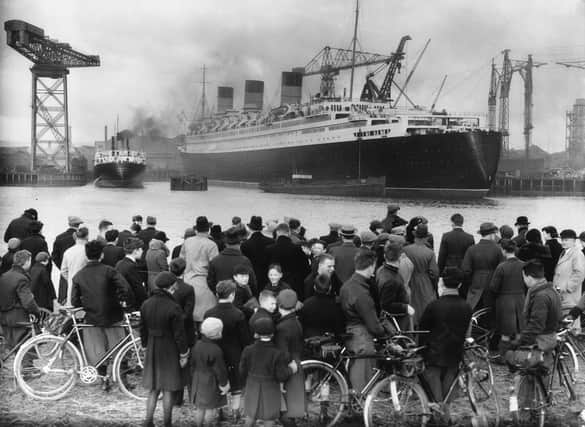 A crowd admires the nearly completed Cunard White Star liner Queen Mary at Clydebank.   (Photo by Hudson/Getty Images)