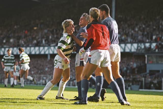 Celtic striker Frank McAvennie is held by the throat by Rangers defender Graham Roberts