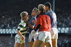 Celtic striker Frank McAvennie is held by the throat by Rangers defender Graham Roberts as goalkeeper Chris Woods and Terry Butcher (r) look on