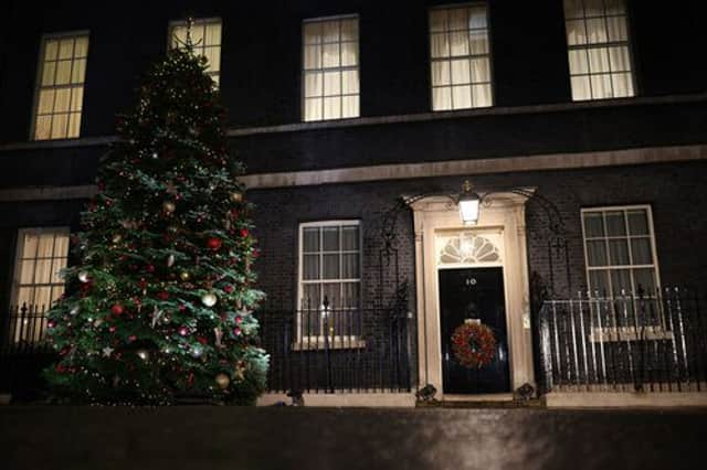 A Christmas tree stands illuminated outside number 10 Downing Street (Getty Images)