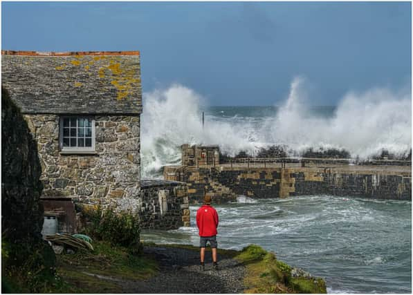 National Trust ranger Seth Jackson looks on as large waves caused by Storm Ellen strike Cornwall in 2020 (Photo by Hugh R Hastings/Getty Images)