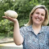 Laura Black posing with her award-winning haggis on the left and her haggis award on the right