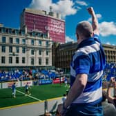 A fan cheers on his favourite team from the stand in Glasgow