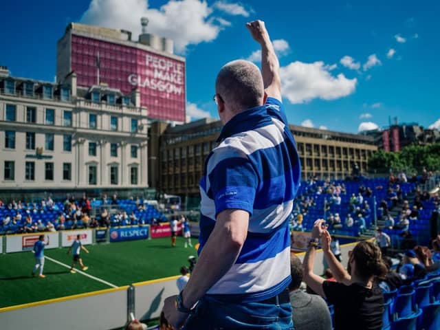 A fan cheers on his favourite team from the stand in Glasgow