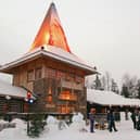 Visitors gather outside of Santa’s office at Santa Claus Village on the Arctic Circle near Lapland on December 21, 2002.