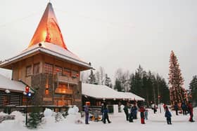 Visitors gather outside of Santa’s office at Santa Claus Village on the Arctic Circle near Lapland on December 21, 2002.