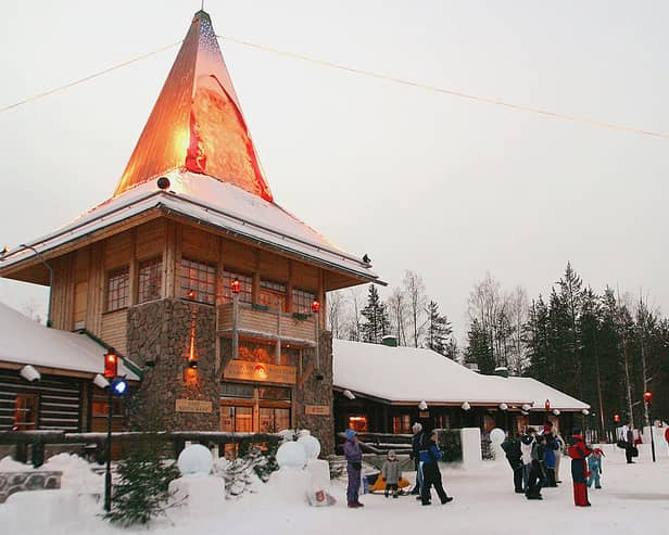 Visitors gather outside of Santa’s office at Santa Claus Village on the Arctic Circle near Lapland on December 21, 2002.