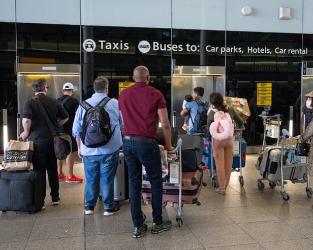 People queue for a lift at Heathrow Airport.