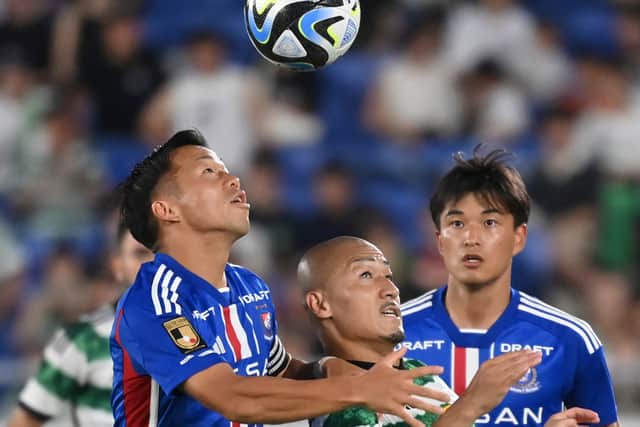 Celtic's forward Daizen Maeda (C) and Japan's Yokohama F Marinos' midfielder Takuya Kida (L) fight for the ball 