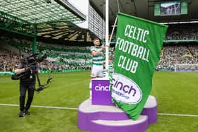 Celtic winger James Forrest raises the league champions flag ahead of kick-off (Credit: SNS Group)