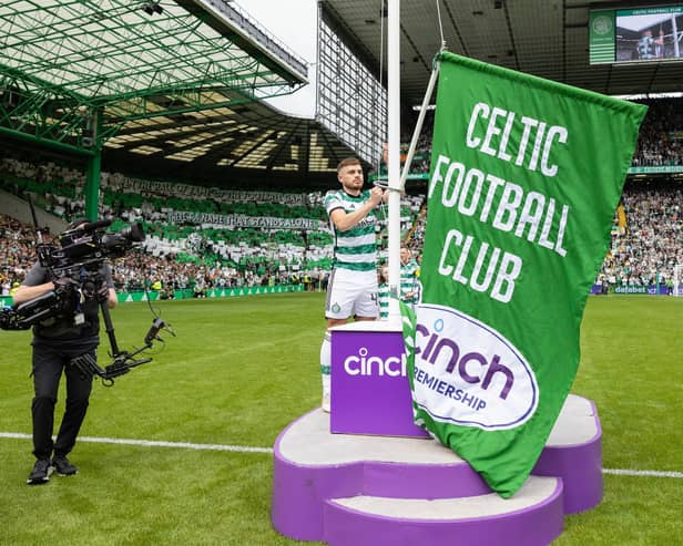 Celtic winger James Forrest raises the league champions flag ahead of kick-off (Credit: SNS Group)