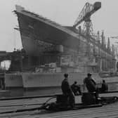 Workers at the John Brown shipyard in Clydebank admire their work on the  Cunard White Star liner ‘Queen Elizabeth’ which towers above two destroyers being built for the Argentinian navy.