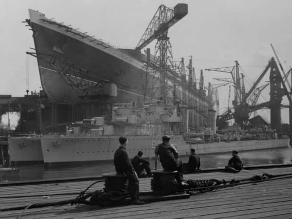 Workers at the John Brown shipyard in Clydebank admire their work on the  Cunard White Star liner ‘Queen Elizabeth’ which towers above two destroyers being built for the Argentinian navy.