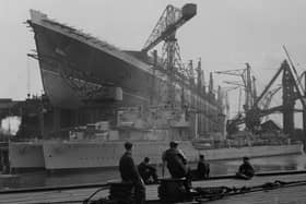 Workers at the John Brown shipyard in Clydebank admire their work on the  Cunard White Star liner ‘Queen Elizabeth’ which towers above two destroyers being built for the Argentinian navy.