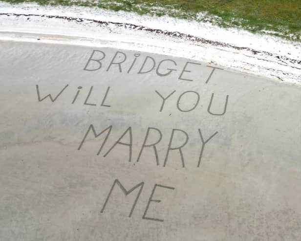 The view the couple got from their flight before landing on the beach - written in the sand the proposal reads:”Bridget will you marry me"