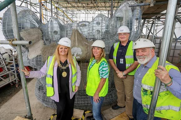 Glasgow's Lord Provost places the first tile on the Beithir, a 121-metre mythical serpent in Scottish folklore, which will form the centrepiece of the community artwork being installed on the site of the new active travel bridge in North Glasgow.