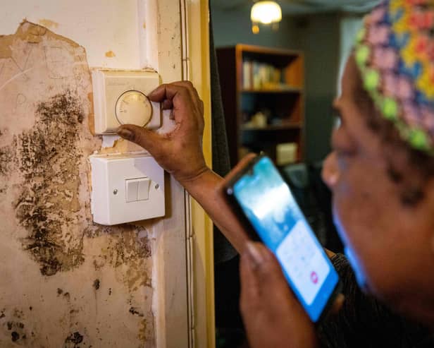 Doreen Thompson adjusts her thermostat at her home as she limits her use of heating to keep up with her increasing energy bills, at her home in south London.