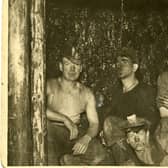 An unnamed group of Wishaw miners at the coalface, 1936. The miners along the back row are wearing caps with fittings for a carbide lamp. These were known locally as 'Yankee caps', either because they were similar to baseball caps or because they were of American manufacture. They were still in use until the 1950s, when they were replaced by helmets made from compressed pulp.