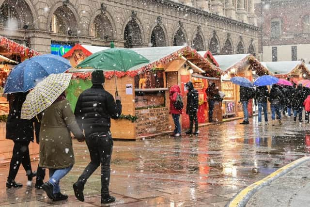 People walk across a Christmas market in downtown Milan - downtown Hamilton will see its own Christmas Markets when the Winter Village arrives at the Hamilton Accies stadium.