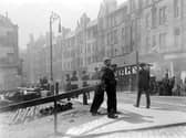 Workers take a brief rest on High Street - note the ornate lamppost and wooden street structures