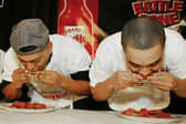 Michael Walker (L) and Meibaka Yohannes eat chicken wings during a preliminary round of the second annual "Battle to the Bone"  Buffalo Wings eating contest held at Madison Square Garden January 22, 2004 in New York City. The winner of the competition, Arnie "Chowhound" Chapman, consumed more than 100 wings in eight minutes. Incredible stuff.