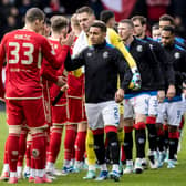 Both teams shake hands at Pittodrie ahead of a Scottish Premiership clash last month.