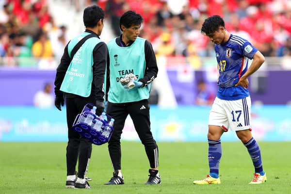 Reo Hatate of Japan leaves the field with medical staff during the AFC Asian Cup Round of 16 match against Bahrain