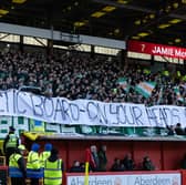 Celtic fans hold up a banner displaying a message to the board 'Celtic Board - on your heads be it'
