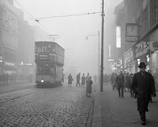 A tram rides down Argyle Street in the fog.