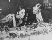 Actors George Peppard and Joan Collins chatting over an evening dinner at the Astoria Beach night club in Athens, May 21st 1969.