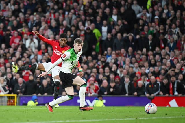 Amad Diallo of Manchester United scores his team's fourth goal whilst under pressure from Conor Bradley of Liverpool during the Emirates FA Cup Quarter Final