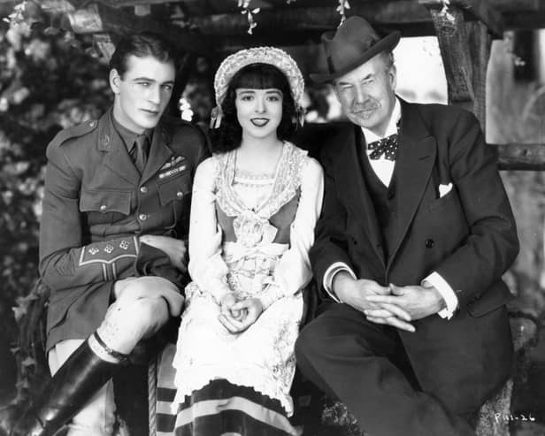 Sir Thomas Johnstone Lipton (1850 - 1931) the Scottish businessman and millionaire philanthropist is visiting Gary Cooper (1901 - 1961) and Colleen Moore (1900 - 1988), leading lady of the silent screen, on the production set of their latest film, 'Lilac Time' (aka 'Love Never Dies'). The film was directed by George Fitzmaurice for First National.  