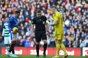 James Tavernier of Rangers (L), stands at the penalty spot with Joe Hart of Celtic and match referee John Beaton 