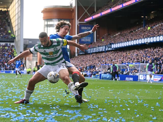 Celtic defender Cameron Carter-Vickers is challenged by Fabio Silva of Rangers as ticker tape litters the pitch at Ibrox