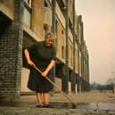 A housewife sweeps her path in the newly-rebuilt Gorbals. The tenements which had formerly occupied this area were among the worst slums in Britain.