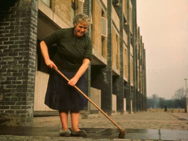A housewife sweeps her path in the newly-rebuilt Gorbals. The tenements which had formerly occupied this area were among the worst slums in Britain.