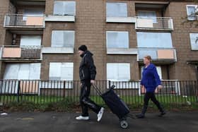 A couple walk past boarded up tenement flats in the Easterhouse area on November 1, 2010 - the most 'miserable day of the year'.