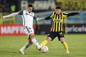 Atletico Mineiro's forward Paulinho (L) and Penarol's Argentine defender Damian Garcia fight for the ball 