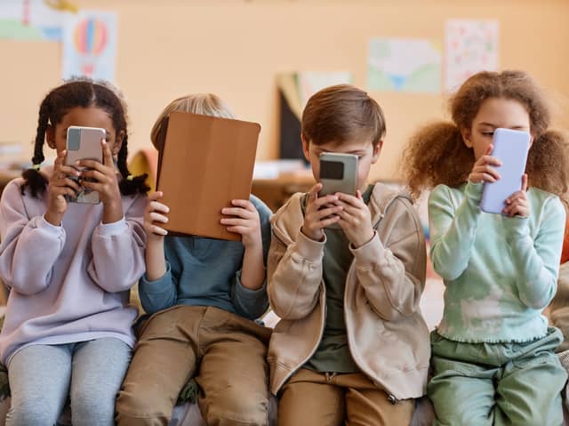 Group of young children holding smartphones. Photo: Seventyfour - stock.adobe.com