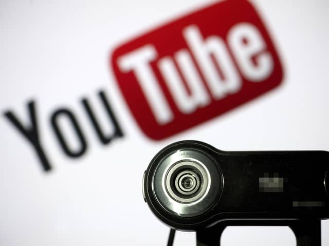 File photo of a camera positioned in front of YouTube's logo. Photo: LIONEL BONAVENTURE/AFP via Getty Images
