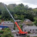 A truck is removed by a crane after getting stuck on a narrow lane in Forder near Saltash, Cornwall.