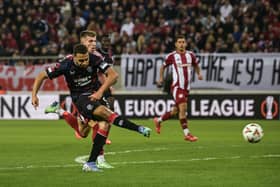 Rangers' forward Cyriel Dessers (L) scores his team's first goal during the UEFA Europa League clash against Olympiacos