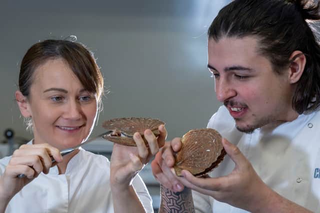 Michelin-starred chef Lorna McNee showing Rory Doherty, cookery student at City of Glasgow College, how to shuck a hand-dived scallop at masterclass organised by Seafood Scotland
